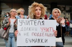 Las protestas en las calles de Bielorrusia se han intensificado ante lo que llaman un fraude electora. En la imagen, una mujer sostiene un cartel que dice: "Los maestros deben enseñar, no falsificar trabajos".