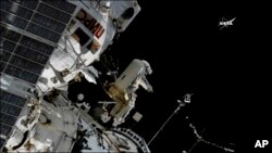 En esta imagen tomada de un video provisto por NASA el astronauta Sergey Prokopyev lanza un nano-satélite Sirius desde la Estación Espacial Internacional. 15 de agosto de 2018.