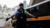 (FILE) A police officer stands guard as a prison van arrives at the West Kowloon Magistrates' Courts building, in Hong Kong, China November 19, 2024.