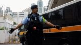 (FILE) A police officer stands guard as a prison van arrives at the West Kowloon Magistrates' Courts building, in Hong Kong, China November 19, 2024.