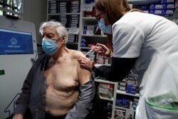 FILE - A pharmacist administers the AstraZeneca COVID-19 vaccine to a patient in a pharmacy in Paris as part of the coronavirus disease vaccination campaign, March 19, 2021.