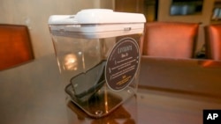 This Dec. 1, 2018 photo shows a locked box holding cell phones during a digital detox visit to the Wyndham Grand Hotel in Chicago. A growing number of hotels are helping guests take a vacation by locking up their cell phones. (AP Photo/Teresa Crawford)