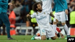 Le défenseur brésilien Marcelo du Real Madrid jubile à genou à la fin de la demi-finale de l'UEFA Champions League match de football entre le Real Madrid et le Bayern Munich au Stade Santiago Bernabeu de Madrid le 1er mai 2018.