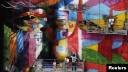 L'artiste graffiti brésilien Eduardo Kobra met la touche finale à son œuvre de 56 mètres de haut en hommage à l'architecte Oscar Niemeyer, l'un des architectes modernistes les plus influents du 20ème siècle, au centre financier de l'avenue Paulista de São Paulo, le 22 janvier 2013.