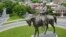 FILE - The statue of Confederate Gen. Robert E. Lee stands in the middle of a traffic circle on Monument Avenue in Richmond, Virginia.