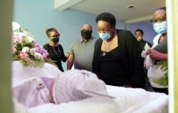 Mourners wear masks at a viewing for COVID-19 victim Shirley Sellers in Alexandria, Virginia, May 14, 2020.