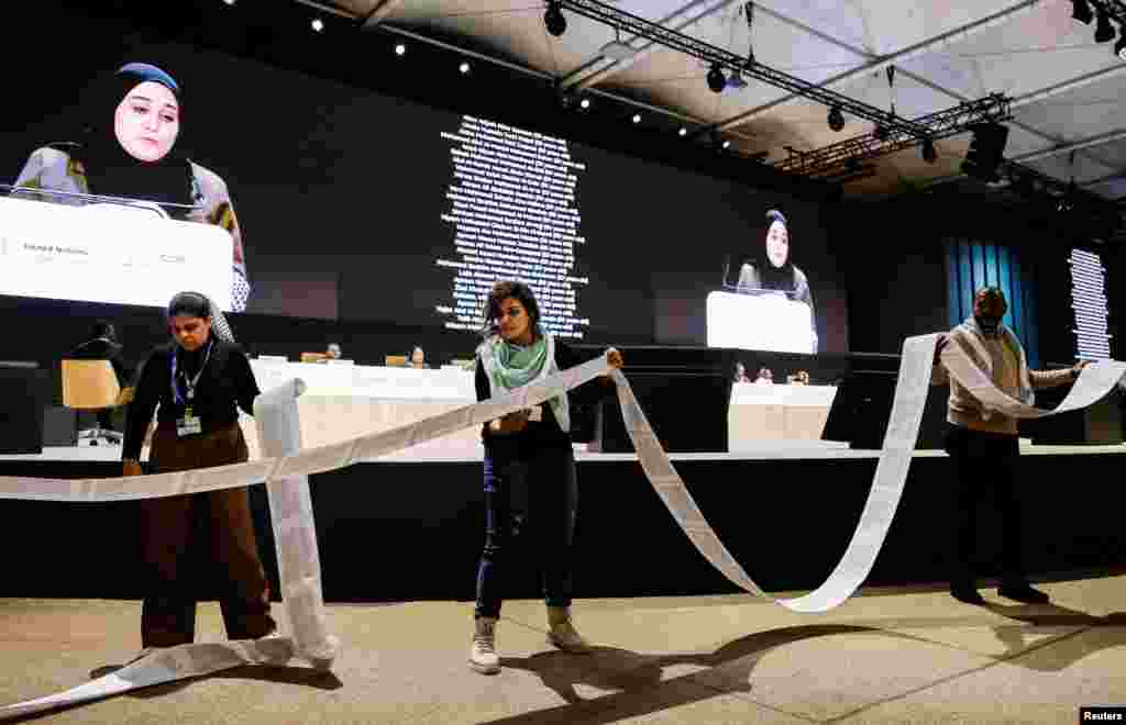 Activists clasp  a rotation  of insubstantial  with the names of the victims of the struggle  betwixt  Israel and Hamas arsenic  an activistic  delivers a code   during the &quot;People&#39;s Plenary&quot; astatine  the COP29 United Nations clime  alteration  conference, successful  Baku, Azerbaijan.