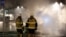 Firefighters keep an eye on several cars that were set on fire during a riot, according to local media, in Rinkeby suburb, outside Stockholm, Sweden, Feb. 21, 2017. 