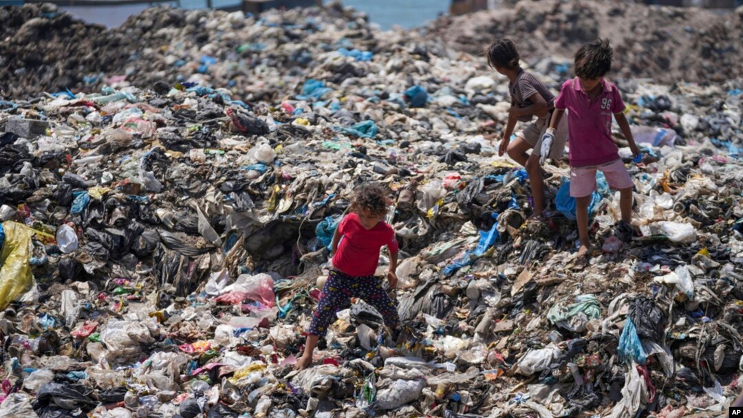Palestinska djeca prebiru smeće u izbjegličkom kampu Nuseirat, Pojas Gaze, 20. juna 2024. Izraelski rat u Gazi desetkovao je sanitarni sistem pojasa, ostavljajući mnoge Palestince da žive u šatorskim kampovima u blizini vode zagađene kanalizacijom i rastućih gomila smeća.