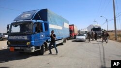 Trucks laden with aid for displaced Syrians wait to cross from Jordan to the Syrian side of the border, in Jabir As Sirhan, Jordan, July 1, 2018. 