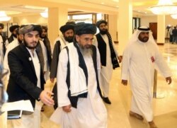 In this Sept. 12, 2020 photo, a Taliban delegation arrive to attend the opening session of the peace talks between the Afghan government and the Taliban in Doha, Qatar.
