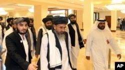 FILE - In this Sept. 12, 2020 photo, a Taliban delegation arrive to attend the opening session of the peace talks between the Afghan government and the Taliban in Doha, Qatar.