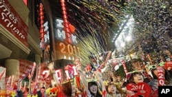 Revelers wave banners and signs during the New Year's Eve celebrations in Hong Kong's Times Square, Jan 1, 2011