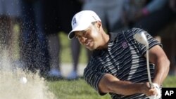 Tiger Woods blast from a bunker during the Farmers Insurance Open golf tournament in San Diego, Jan. 29, 2011 (file photo).
