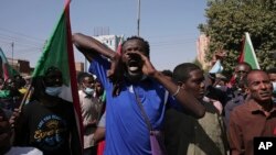 FILE: Tens of thousands of Sudanese calling for a civilian government march near the presidential palace in Khartoum, Sudan, Tuesday, Nov. 30, 2021