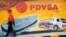 Un empleado de una estación de servicio de Caracas pasa frente a un mural con el logo de la estatal petrolera PDVSA, en agosto de 2014.