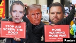 People wearing head cut-outs of U.S. President Donald Trump, center, U.S. Vice President JD Vance, right, and Alternative for Germany (AfD) party co-leader Alice Weidel protest at the Munich Security Conference, in Munich, Germany, Feb. 14, 2025.