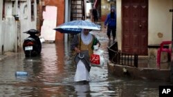 People walk through floodwaters in Beirut's southern suburb of Ouzai, Lebanon, Dec. 9, 2019. 