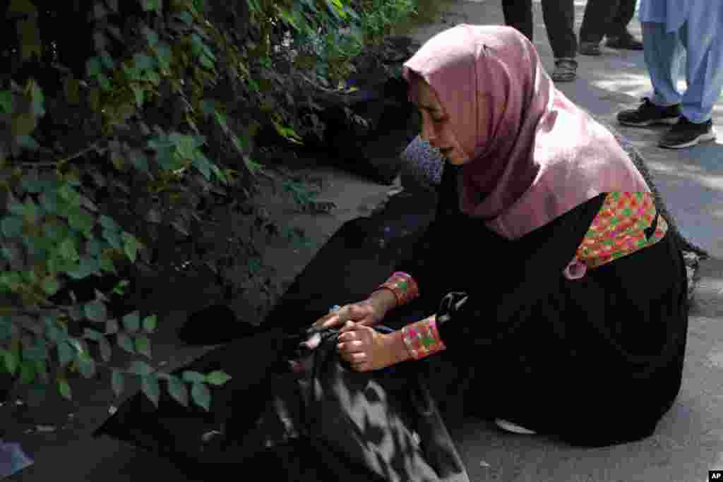An Afghan woman tries to identify a dead body at a hospital in Kabul, Afghanistan, Aug. 27, 2021, a day after deadly attacks outside the airport.