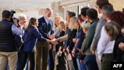 El rey de España, Felipe VI, y la reina Letizia saludan a residentes del poblado de Uriel, en la región de Valencia, después de las inundaciones de finales de octubre, el 19 de noviembre de 2024.