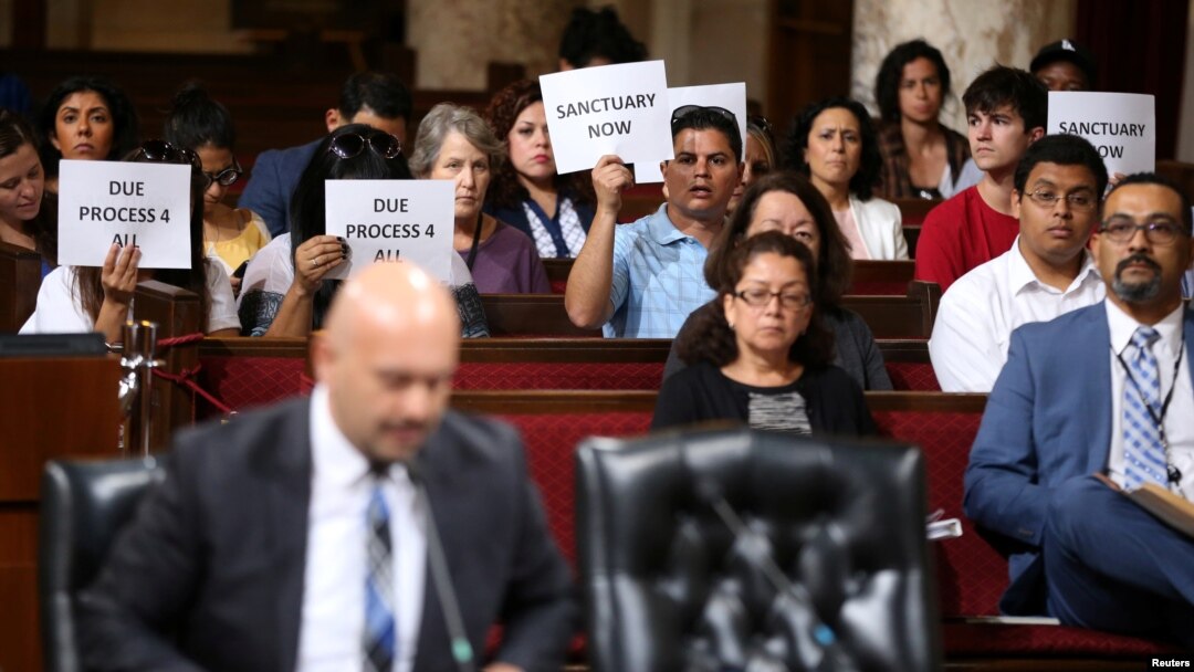 Immigrant supporters protest during a Los Angeles City Council ad hoc committee on immigration meeting to discuss the city's response to threats by the Trump administration to cut funding from Los Angeles and other jurisdictions that federal officials say are providing sanctuary to illegal immigrants arrested for crimes, March 30, 2017.