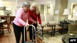 Alexis McKenzie, right, executive director of an Alzheimer's assisted-living home in Washington, walks with resident Catherine Peake in February