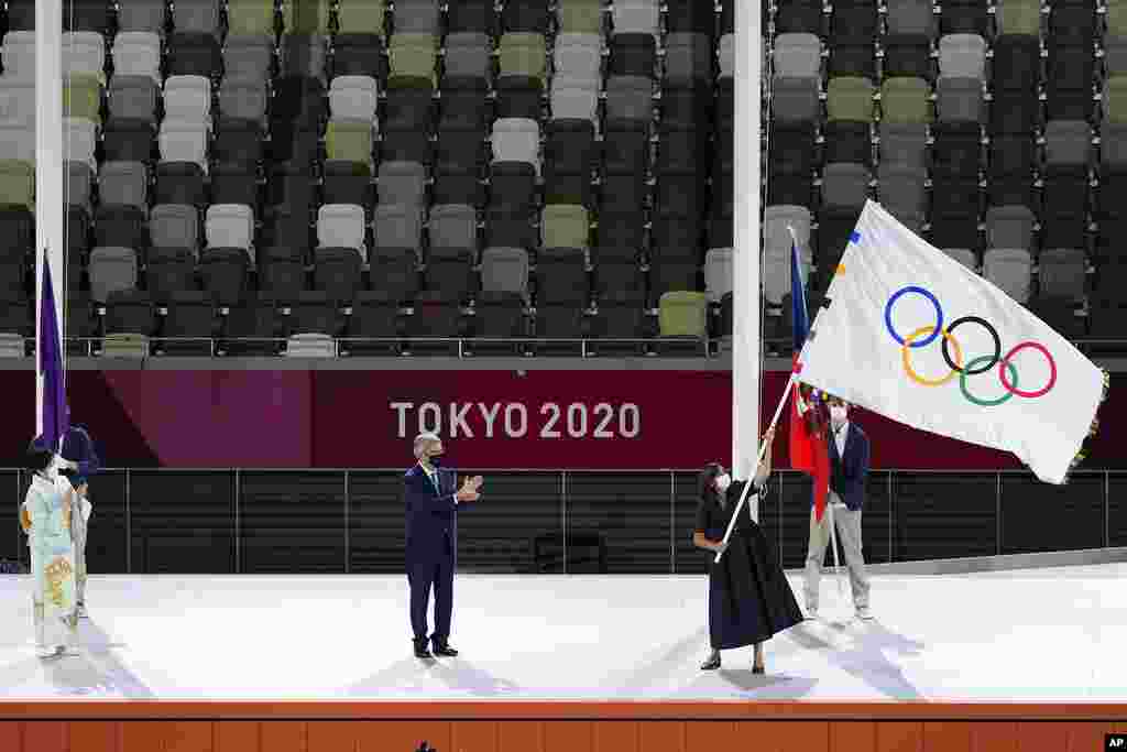 Paris mayor Anne Hidalgo, right, holds the Olympic flag next International Olympic Committee&#39;s President Thomas Bach, center, and Tokyo Gov. Yuriko Koike, left, during the closing ceremony in the Olympic Stadium at the 2020 Summer Olympics, Sunday, Aug. 8, 2021, in Tokyo, Japan. (AP Photo/Lee Jin-man)