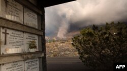 The smoking lava flow from the Cumbre Vieja volcano is seen from the cemetery of the neighborhood of Todoque in Los Llanos de Aridane on the Canary island of La Palma in Sept. 24, 2021.