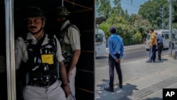 Indian paramilitary soldiers and policemen guard from behind a temporary security post as delegates from the Group of 20 nations arrive to participate in a tourism meeting in Srinagar, Indian controlled Kashmir, May 22, 2023.