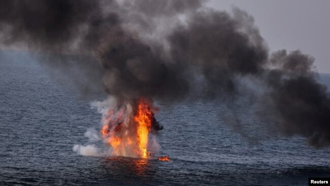 An explosion is seen on an oversea target during a joint exercise called the 'Great Prophet 17', in the southwest of Iran, in this picture obtained on Dec. 22, 2021.