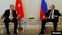Turkish President Recep Tayyip Erdogan speaks to Russian President Vladimir Putin (R) during their meeting in St. Petersburg, Russia, August 9, 2016. 