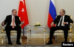 FILE - Turkish President Recep Tayyip Erdogan (L) speaks to Russian President Vladimir Putin during their meeting in St. Petersburg, Russia, Aug. 9, 2016. Erdogan is expected to raise the issue of safe zones in Syria during talks with Putin in Moscow this week.