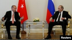 Turkish President Recep Tayyip Erdogan speaks to Russian President Vladimir Putin (R) during their meeting in St. Petersburg, Russia, August 9, 2016. 