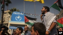 Palestinians march through Manara Square in central Ramallah passing a symbolic wooden chair erected to represent the UN seat they aspire, September 22, 2011