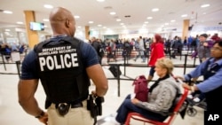 Petugas keamanan mengawasi penumpang di bandara Hartsfield–Jackson, Atlanta (foto: dok). Bandara ini menjadi bandara tersibuk di dunia dengan melayani 100 juta lebih penumpang dalam setahun. 