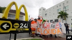 FILE - People protest for increased minimum wages outside a McDonald's restaurant in the Little Havana area in Miami, Florida, Dec. 4, 2014.
