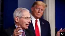 FILE - In this April 22, 2020, photo, President Donald Trump watches as Dr. Anthony Fauci, director of the National Institute of Allergy and Infectious Diseases, speaks about the coronavirus in the James Brady Press Briefing Room of the White House. 