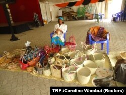 FILE - Faith Karauki displays some finished products in Mathiga Village, Kenya, April 28, 2018.