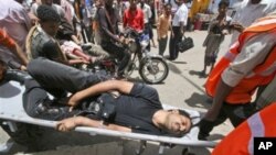 Medics and civilians carry wounded anti-government protesters to a field hospital during clashes with Yemeni security forces in Taiz, Yemen, May 9, 2011