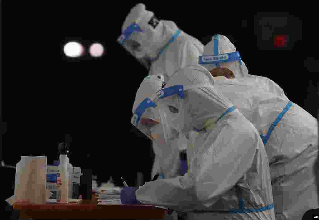 Medical staffers wearing protective suits work at a triage check point that was set to ease the pressure on hospital emergency wards, following the surge of COVID-19 case numbers, in Milan, Italy.