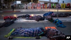 Migrants sleep on a street near the Chaparral border crossing in Tijuana, Mexico, Nov. 23, 2018. 
