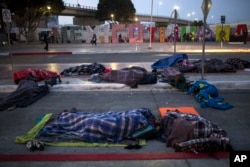 Migrants sleep on a street near the Chaparral border crossing in Tijuana, Mexico, Nov. 23, 2018.