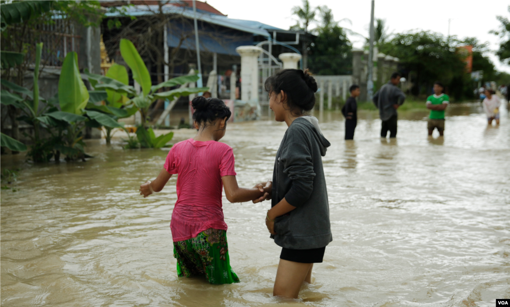 Girls wander through a flooded road in Spean Tmor commune, Dangkoa district, Phnom Penh City, Cambodia, on Oct. 14, 2020. (Malis Tum/VOA Khmer)