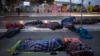 Migrants sleep on a street near the Chaparral border crossing in Tijuana, Mexico, Nov. 23, 2018. 