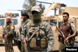 FILE - Fighters of Syrian Democratic Forces (SDF) are seen in Deir el-Zour, Syria, May 1, 2018.