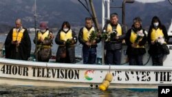 A monk accompanies people whose family members are still missing in the March 11, 2011 earthquake and tsunami offering prayers as Japanese Coast Guard divers conduct an underwater search Thursday, March 10, 2016 in Hirota Bay in Rikuzentakata. (AP Photo/Koji Ueda)