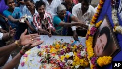 Para pendukung mantan pejabat tertinggi negara bagian Tamil Nadu, Jayaram Jayalalithaa, memberikan penghormatan terakhir bagi almarhum di depan foto yang diletakkan di depan kantornya di Mumbai, India (6/12).