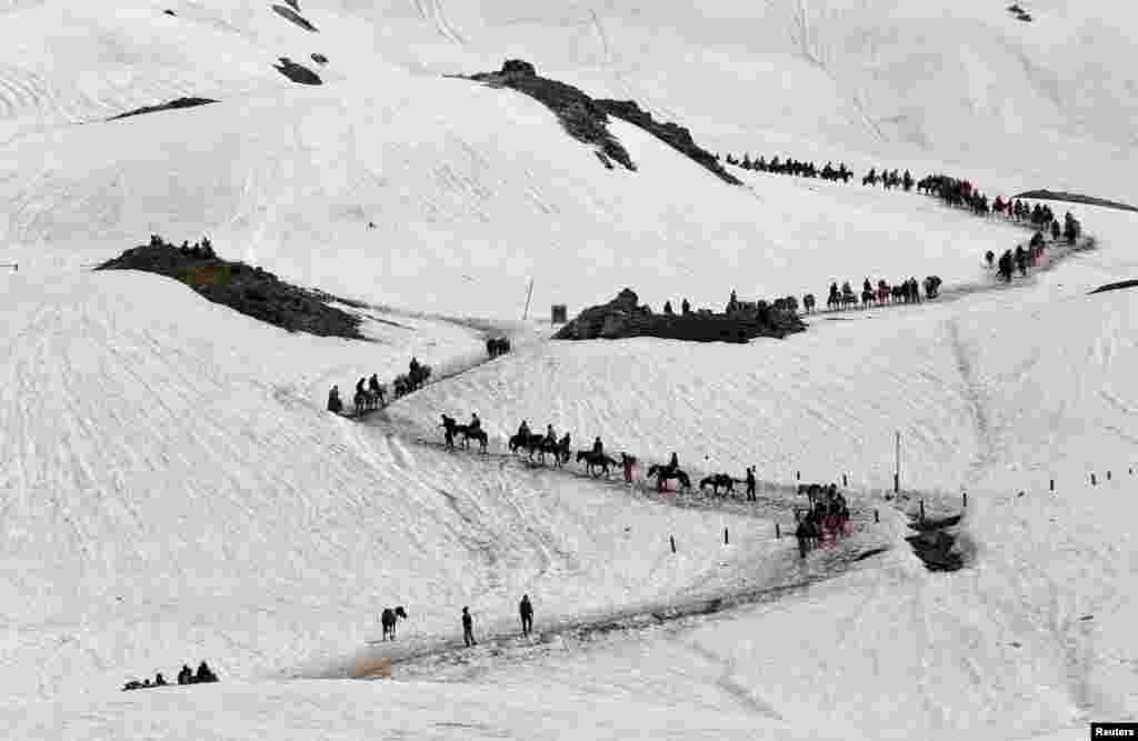 Peziarah Hindu menyeberangi gunung yang tertutup salju untuk mencapai kuil gua Amarnath tempat mereka menyembah stalagmit es yang oleh umat Hindu diyakini sebagai simbol Dewa Siwa, di kota Waval, wilayah Kashmir-India.