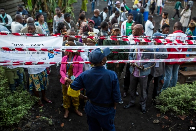 Witnesses and voters wait for the Katendere voting center to open in Goma, Dec. 30, 2018. Voters in the Democratic Republic of the Congo went to the polls Sunday in elections that will shape the future of their vast, troubled country.