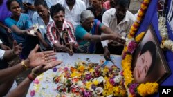 Supporters of India's Tamil Nadu state's former Chief Minister Jayaram Jayalalithaa pay tributes near her photograph outside their party office in Mumbai, India, Dec. 6, 2016.